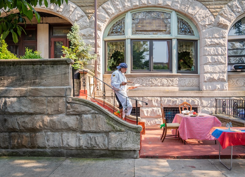 Chef Ararat El-Rawi carrying plates downstairs to serve guests