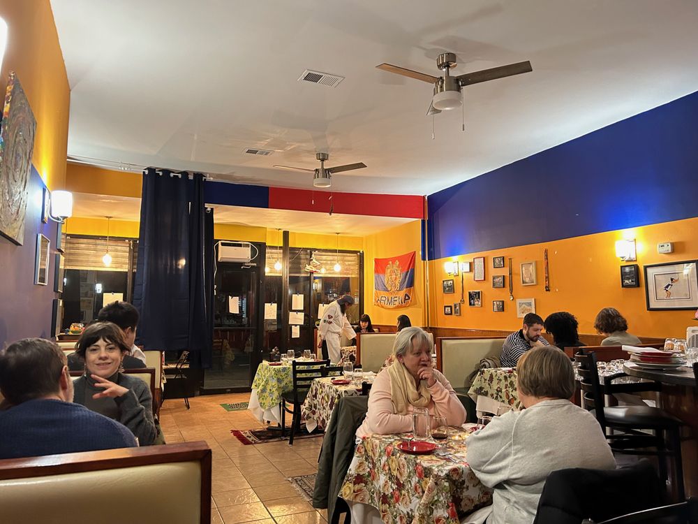 The warm dining room of Cafe Little Armenia full of guests